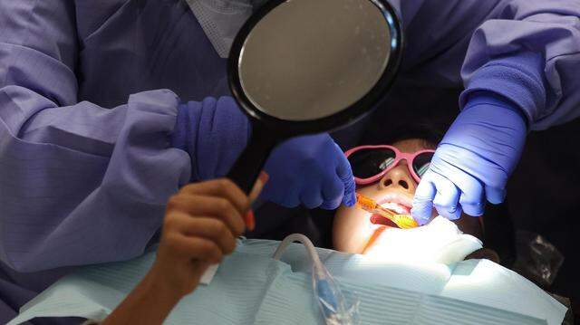 Clara Solorzano, a second year dental hygiene student at Tarrant Community College, cleans 10-year-old Dayana Salazar’s teeth on Friday, November 12, 2021. An associate professor at UNT Health Fort Worth is researching how dental health providers can talk with patients about preventing HPV-related cancers.